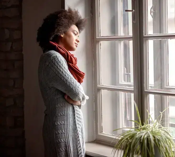 Woman sadly standing at window